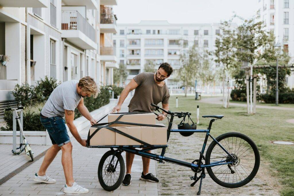 Two men attaching boxes to a cargo bike